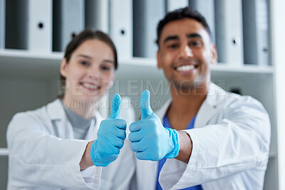 Buy stock photo Closeup shot of two scientists showing thumbs up in a lab
