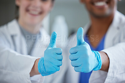 Buy stock photo Closeup shot of two scientists showing thumbs up in a lab