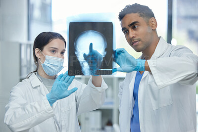 Buy stock photo Shot of two doctors analysing an x-ray together in a hospital