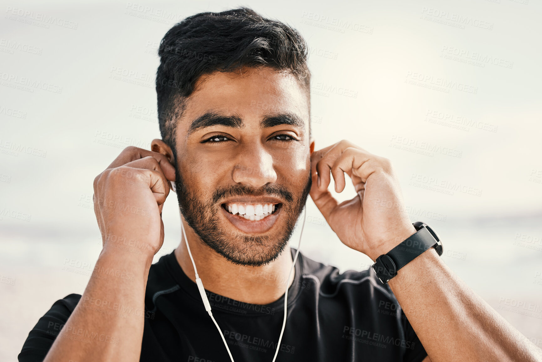 Buy stock photo Happy, man and fitness with earphones for listening to music on run, workout or exercise at beach. Smile, male person and face with audio for podcast and smartwatch for tracking steps or cardio