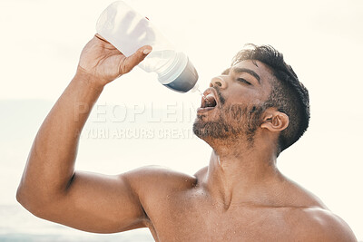 Buy stock photo Shot of a sporty young woman drinking water while out for a run
