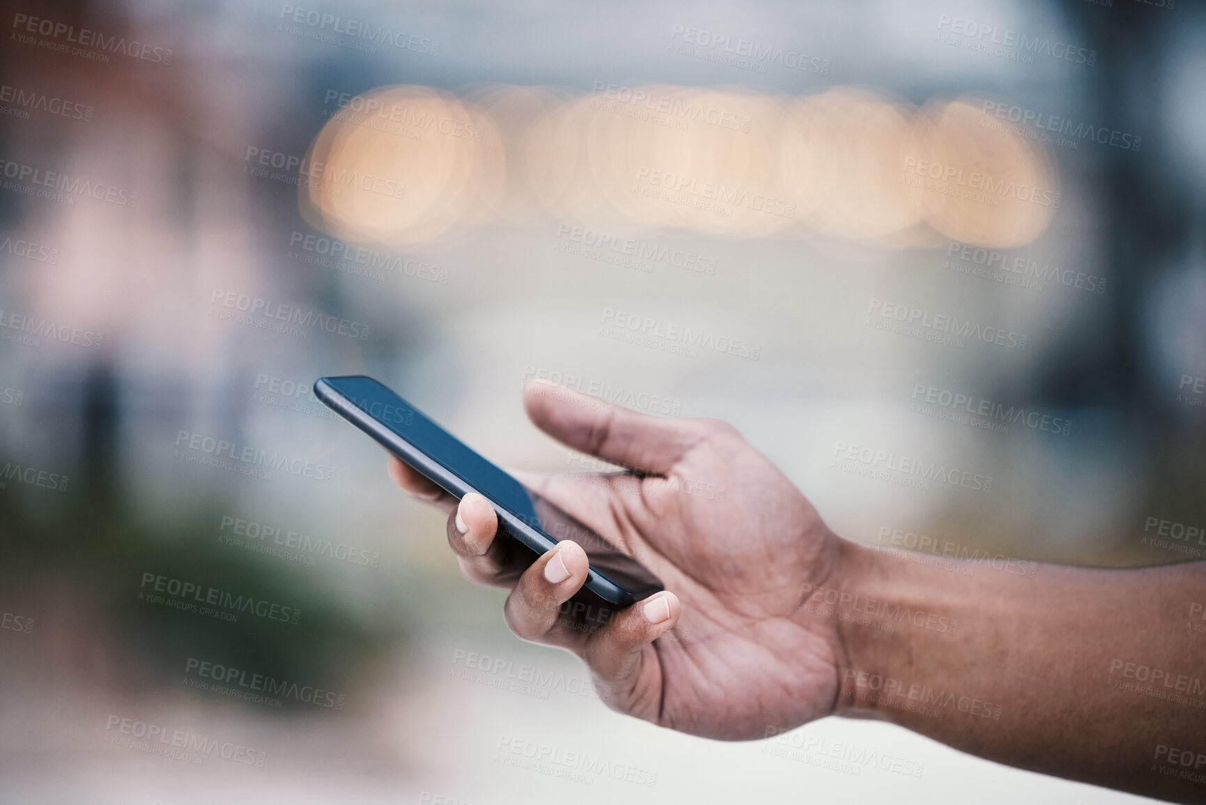 Buy stock photo Cropped shot of an unrecognizable man using his cellphone while standing outside