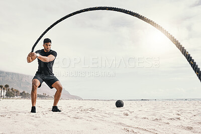 Buy stock photo Shot of a sporty young man exercising outside with heavy ropes