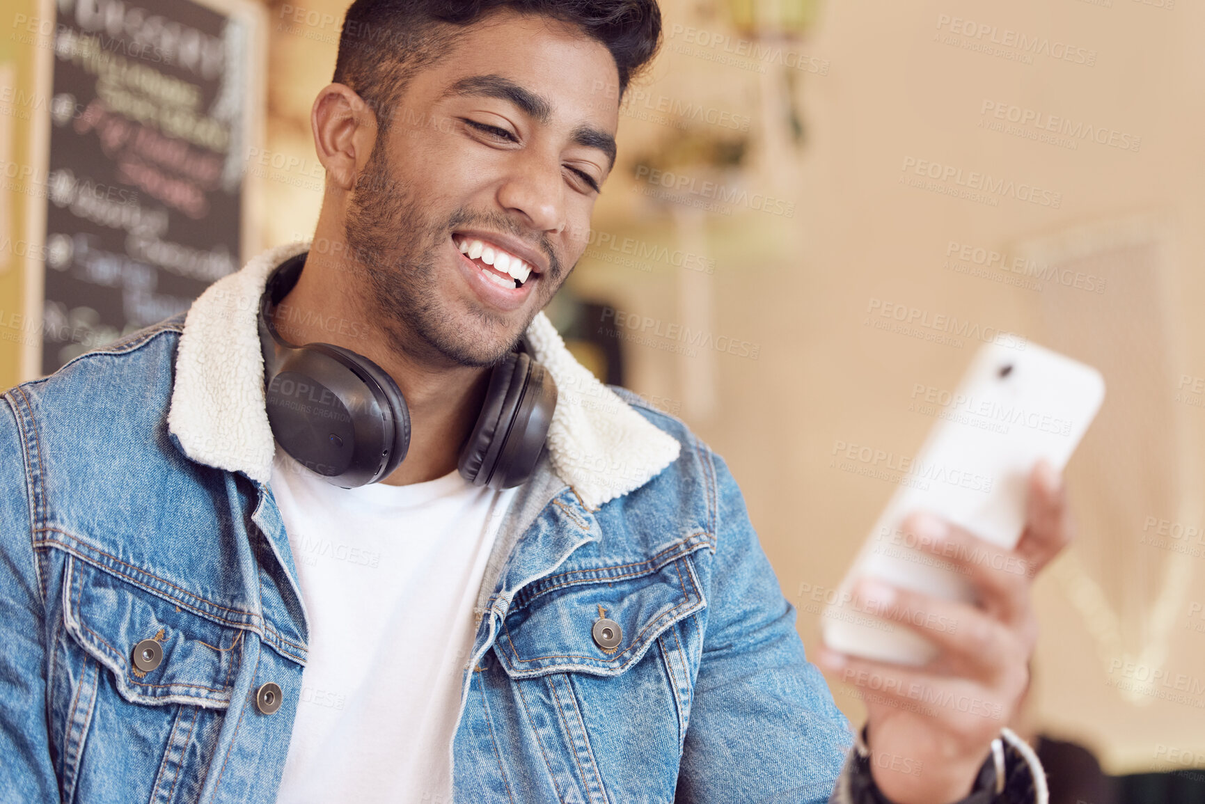 Buy stock photo Smartphone, relax and man in cafe for social media, communication or networking. Online, happiness and male person with headphones for browsing internet, trending update or lunch break in coffee shop