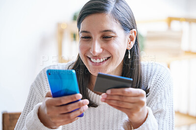 Buy stock photo Shot of a young woman using a laptop and credit card in her living room at home