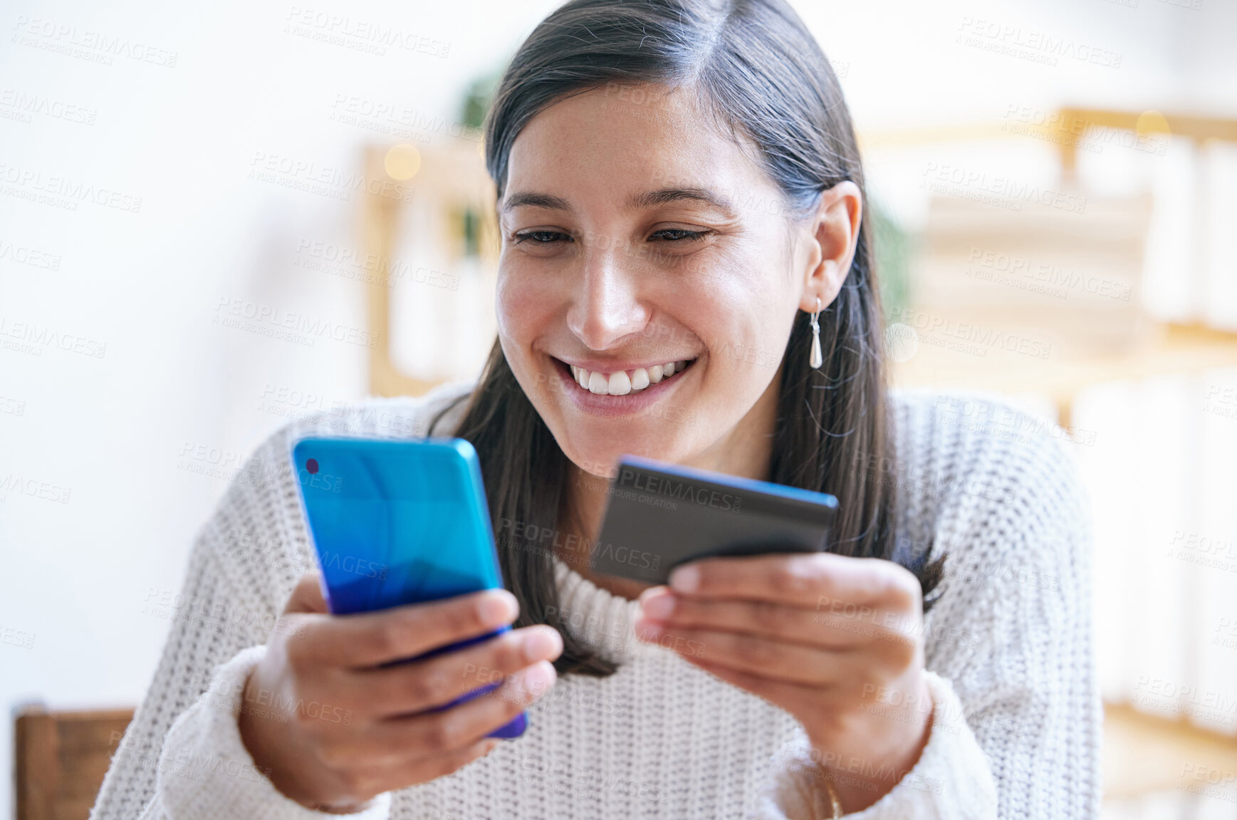 Buy stock photo Shot of a young woman using a laptop and credit card in her living room at home