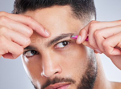 Buy stock photo Beauty, face and man with tweezers in studio for eyebrow, shape and hygiene, grooming or routine on grey background. Brows, pull and Mexican male model with facial hair removal tools for wellness