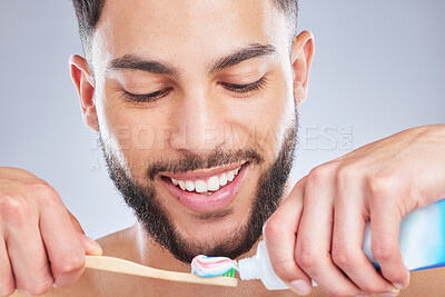 Buy stock photo Brushing teeth, toothbrush and man in studio for wellness, fresh breath and oral care on grey background. Toothpaste, smile or model with bamboo product for mouth, cleaning or bacteria prevention