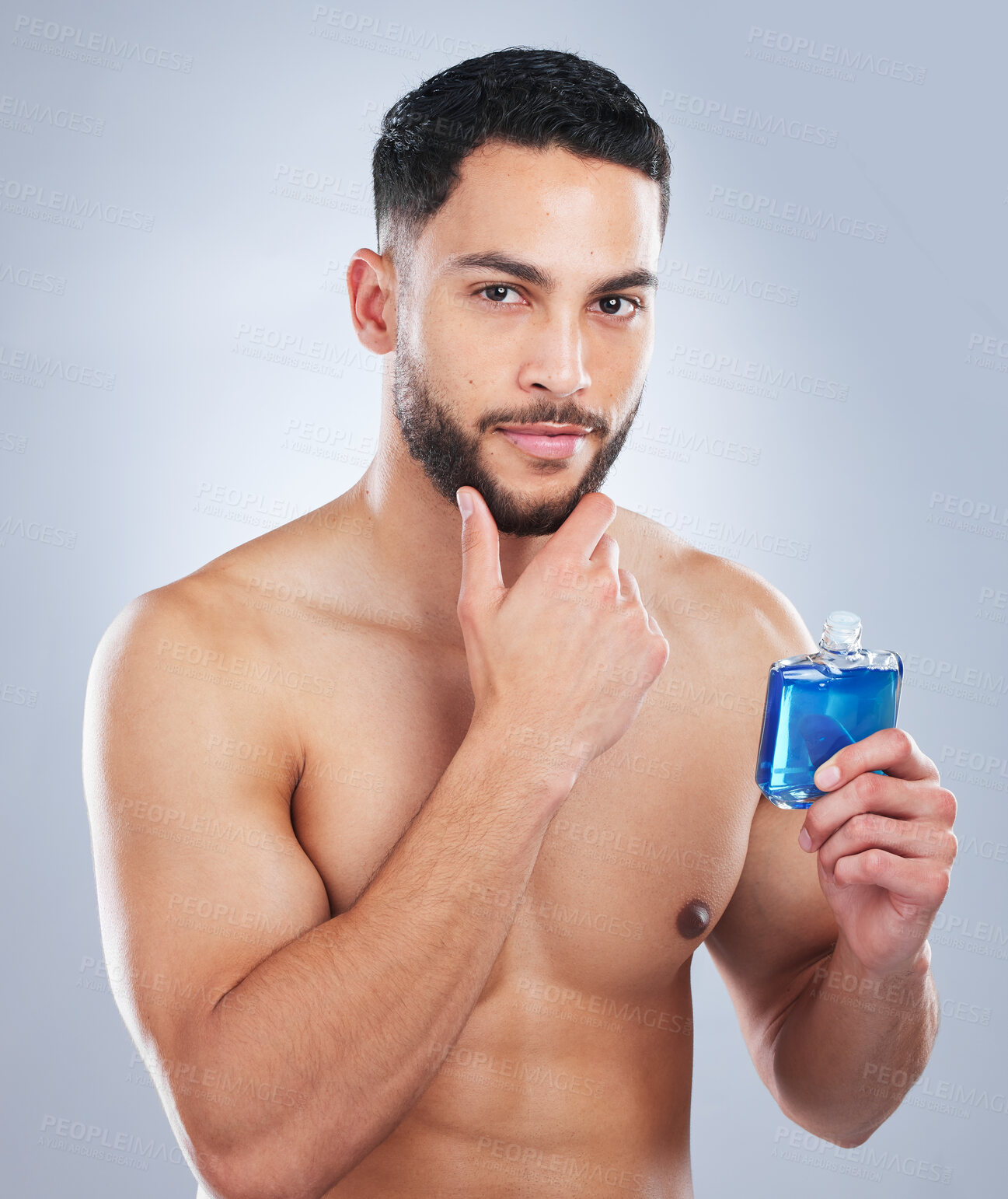 Buy stock photo Studio shot of a handsome young man applying cologne against a grey background