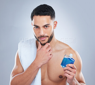 Buy stock photo Studio shot of a handsome young man applying cologne against a grey background