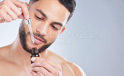 Buy stock photo Mockup, serum and man with skincare, cosmetics and dermatology against a grey studio background. Male person, model and guy with oil, beauty and liquid for face, grooming and routine for smooth skin