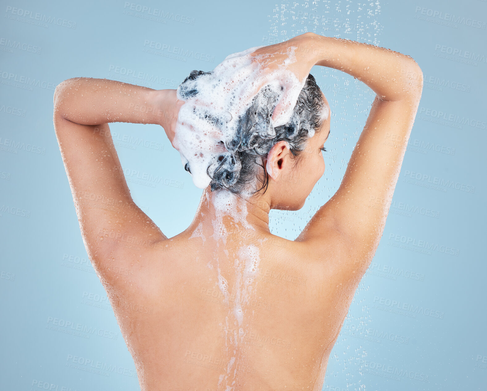 Buy stock photo Girl, shower and shampoo for cleaning hair in studio, soap and water for hygiene on blue background. Female person, cosmetic and foam for haircare or grooming, back and confident for washing routine