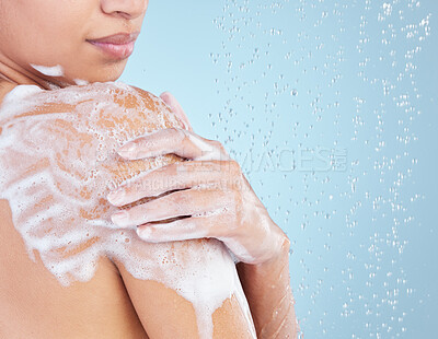 Buy stock photo Studio shot of an unrecognisable woman taking a shower against a blue background