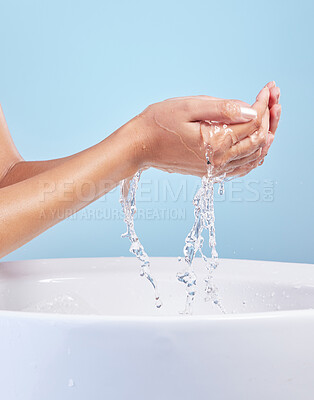 Buy stock photo Shot of an unrecognisable woman washing her hands against a blue background