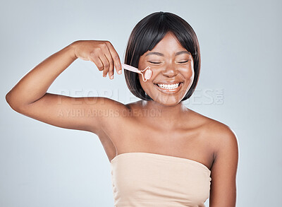 Buy stock photo African woman, rose quartz roller and studio with smile for skin routine with natural glow by background. Girl, person and happy with stone, crystal or product for beauty, health and cosmetic change
