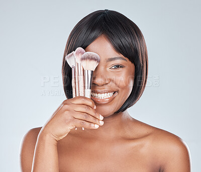 Buy stock photo Studio shot of an attractive young woman using a makeup brush against a grey background