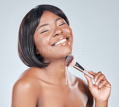 Buy stock photo Studio shot of an attractive young woman using a makeup brush against a grey background