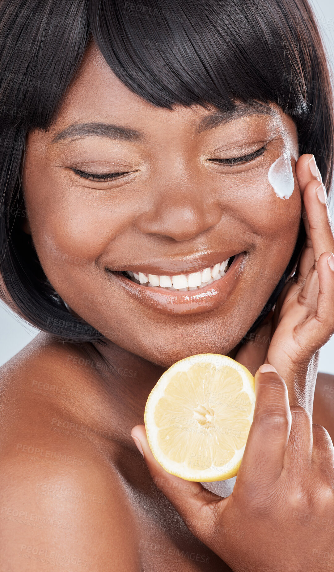 Buy stock photo Happy, black woman and lemon with cream for vitamin C, facial treatment or detox on a studio background. Face of African, female person or young model with smile for collagen, citrus or natural fruit