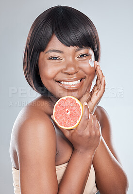 Buy stock photo Black woman, portrait and grapefruit with cream for vitamin C, facial treatment or skincare on a white studio background. Happy African, female person or model with smile, natural fruit or collagen