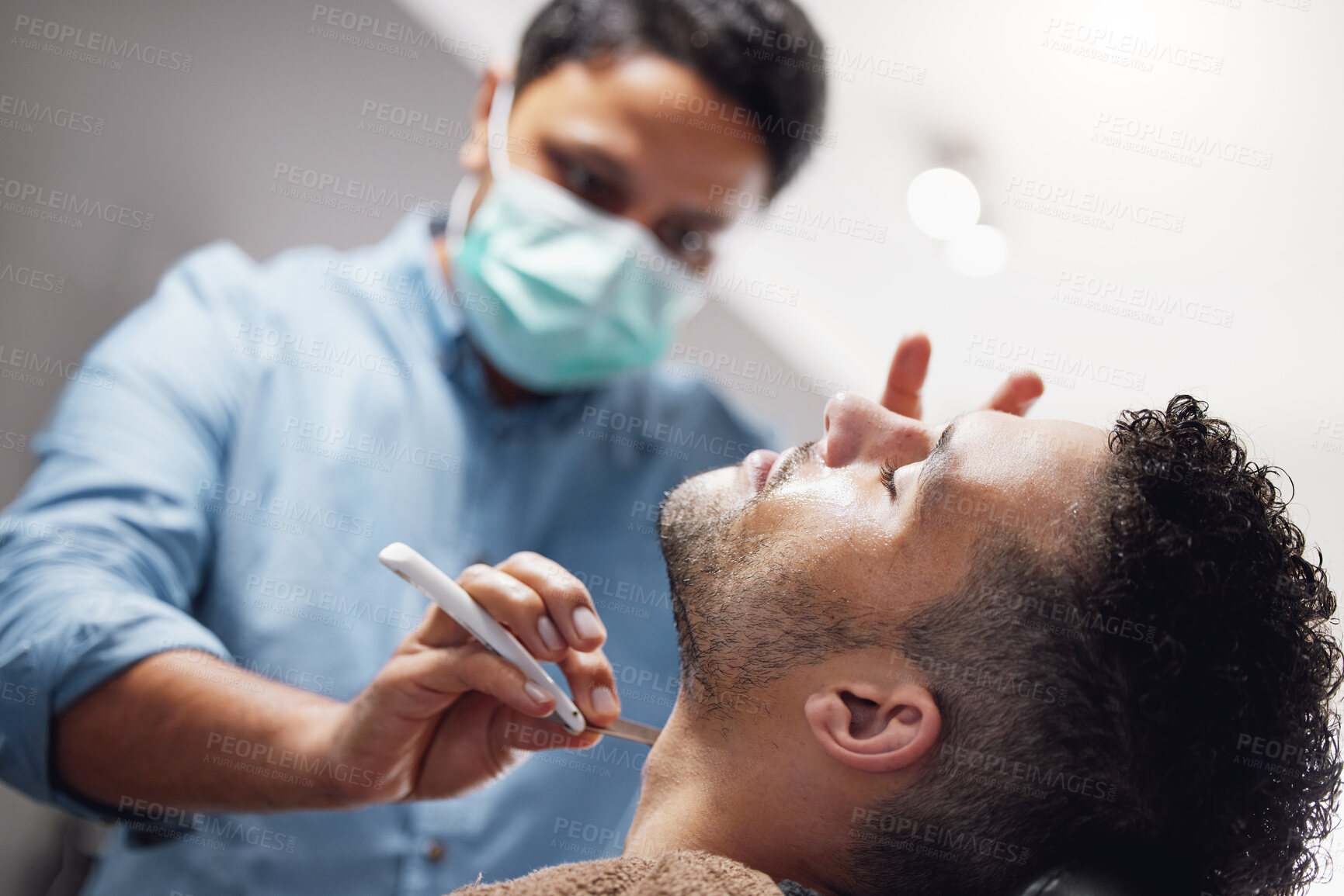 Buy stock photo Cropped shot of a handsome young man getting groomed by a barber