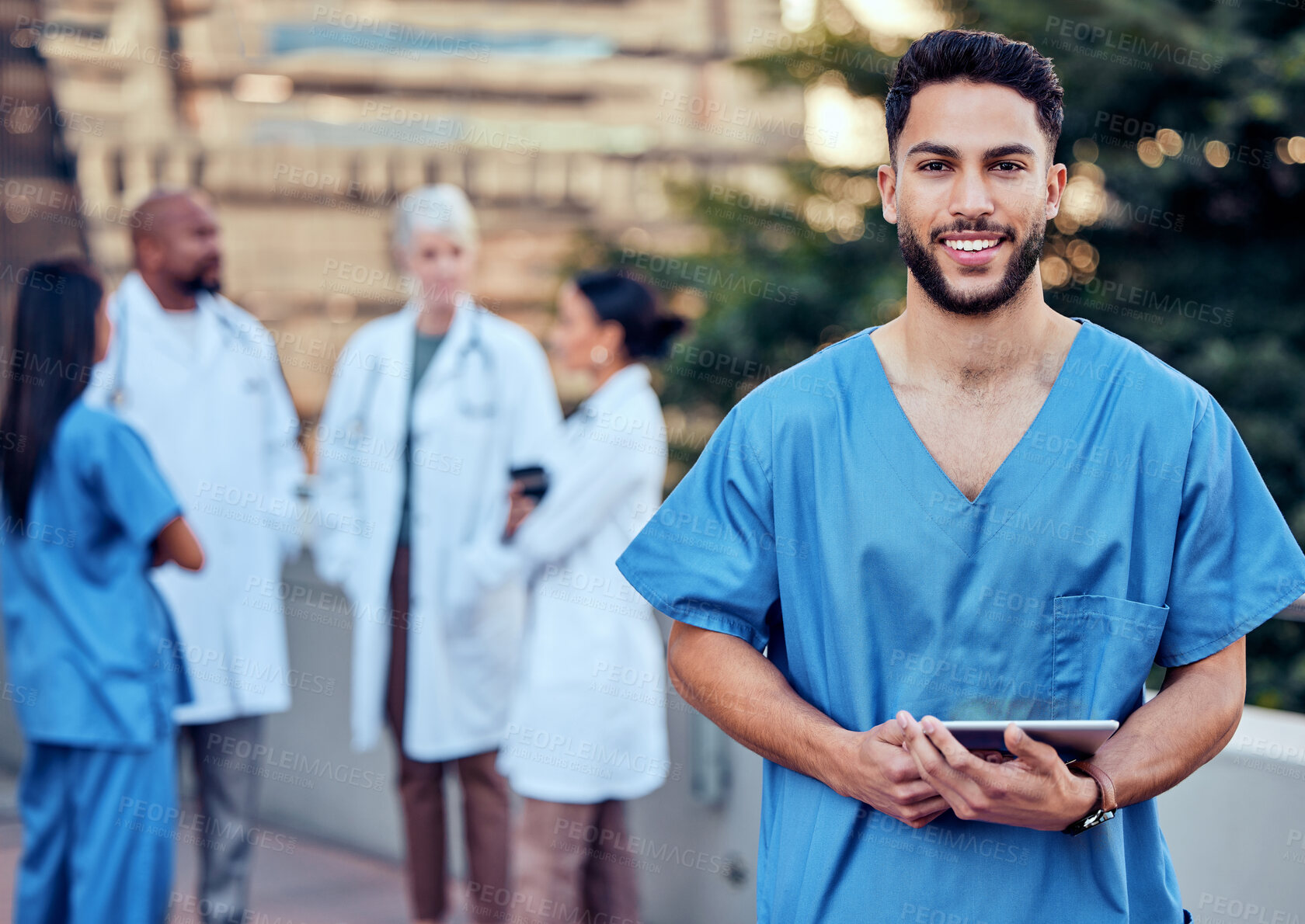 Buy stock photo Shot of a young male doctor using a digital tablet in the city