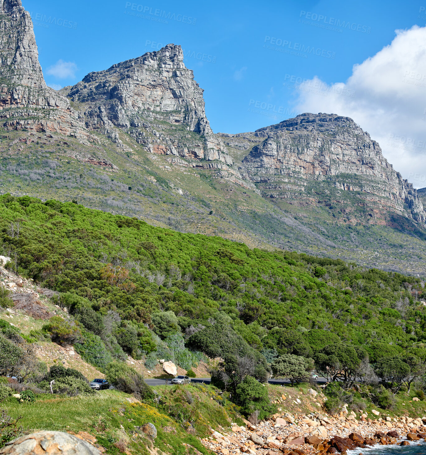 Buy stock photo Twelve Apostles at Table Mountain in Cape Town against a cloudy blue sky background. Scenic landscape view of lush green plants and trees growing around a majestic rocky valley to explore in nature
