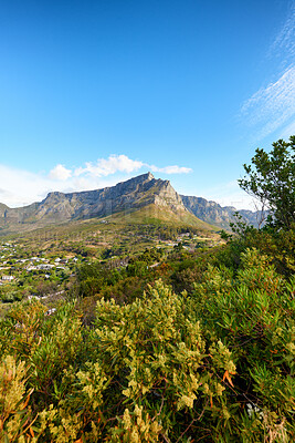 Buy stock photo Natural green trees, bushes and a blue sky overlooking rocky cliffs on a hill. Beautiful landscape view of a mountain with fora in nature. Background of dry and grassy terrain in the great outdoors