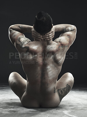 Buy stock photo Monochrome shot of a muscular young man posing nude in studio against a dark background