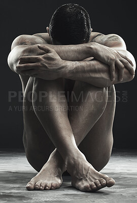 Buy stock photo Monochrome shot of a muscular young man posing nude in studio against a dark background