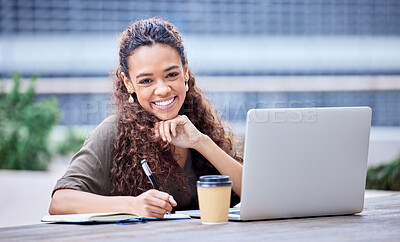 Buy stock photo Shot of a young businesswoman using a laptop and notebook at work