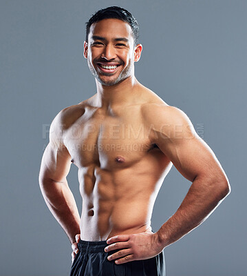 Buy stock photo Studio portrait of a muscular young man posing against a grey background