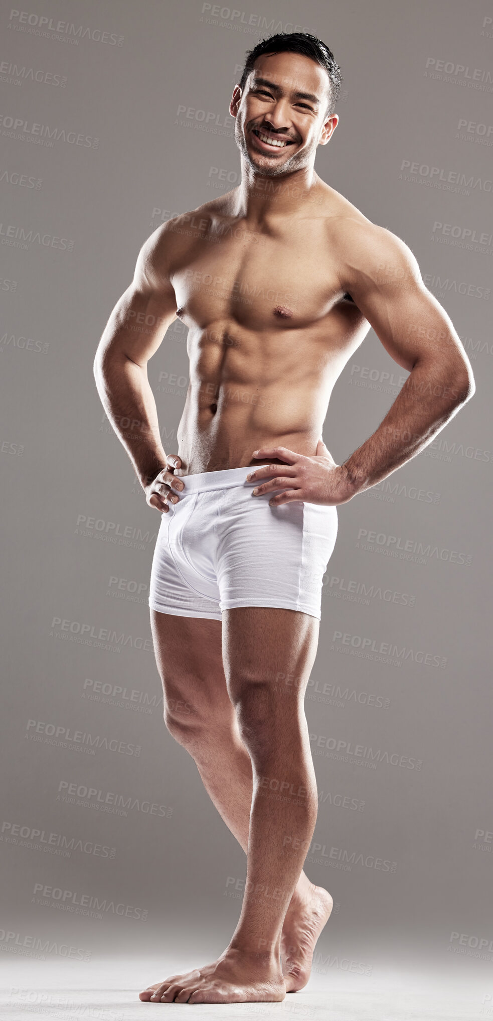 Buy stock photo Studio portrait of a muscular young man posing against a grey background