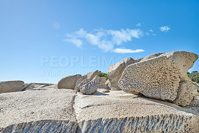 Buy stock photo Big boulders on a rocky coast outside on a summer day. Landscape view of a beautiful beach and seashore under a clear blue sky. A natural seaside environment and marine habitat with copy space