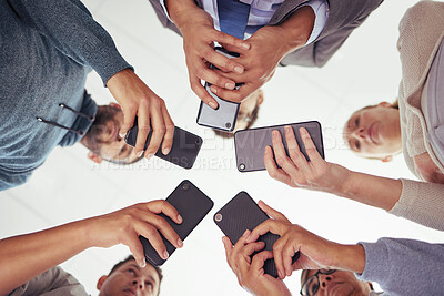 Buy stock photo Shot of a group of young businesspeople using their cellphones against a white background