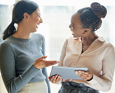 Buy stock photo Cropped shot of two attractive young businesswomen looking at a tablet together in the office