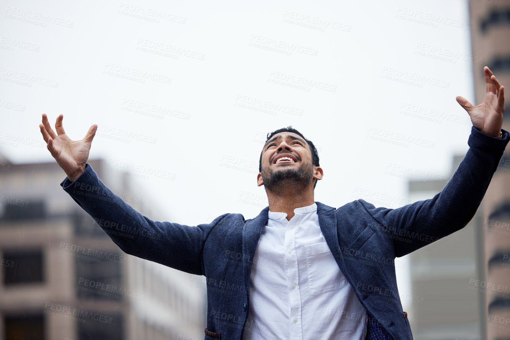 Buy stock photo Cropped shot of a handsome young businessman standing outside in the city with his arms raised in jubilation