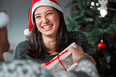 Buy stock photo Shot of a young couple exchanging gifts on Christmas at home