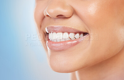 Buy stock photo Closeup shot of an unrecognizable woman smiling against a blue background