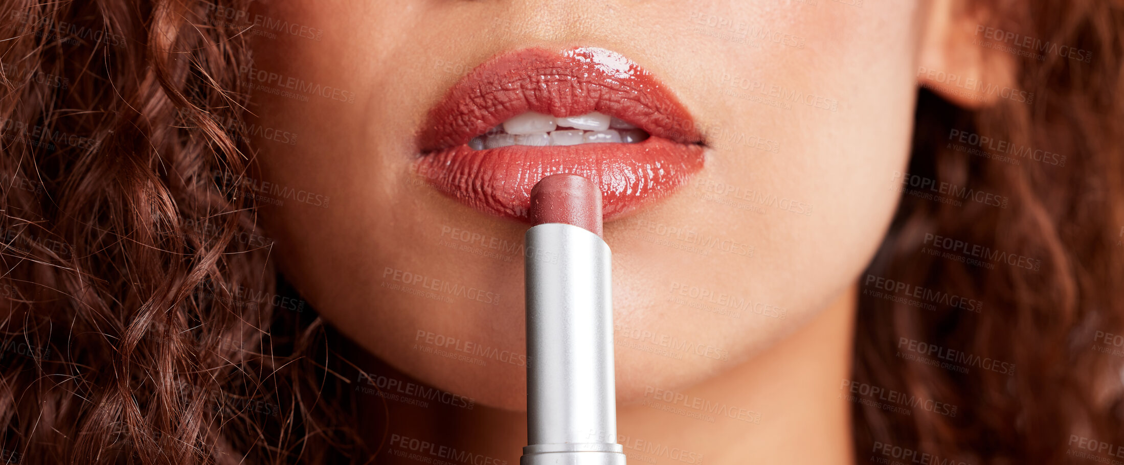 Buy stock photo Closeup shot of a young woman applying lipstick