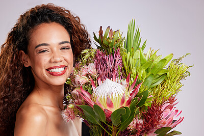 Buy stock photo Shot of a young woman holding a bouquet of flowers against a pink background