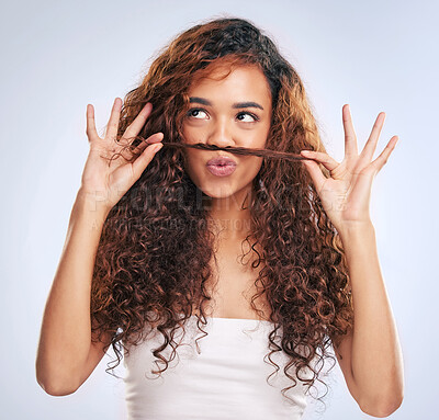 Buy stock photo Cropped shot of an attractive young woman making a moustache with her hair in studio against a grey background