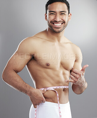Buy stock photo Man, portrait and measuring tape for weight loss results in studio or confidence, stomach or grey background. Asian person, face and gym fitness as strong athlete or hang ten, progress or shirtless