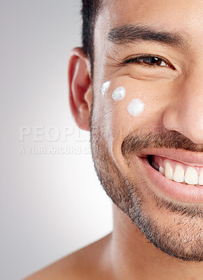 Buy stock photo Closeup, portrait and man with skincare, cream and dermatology against grey studio background. Face, male person and model with lotion, creme and grooming routine with a smile, beauty and smooth skin