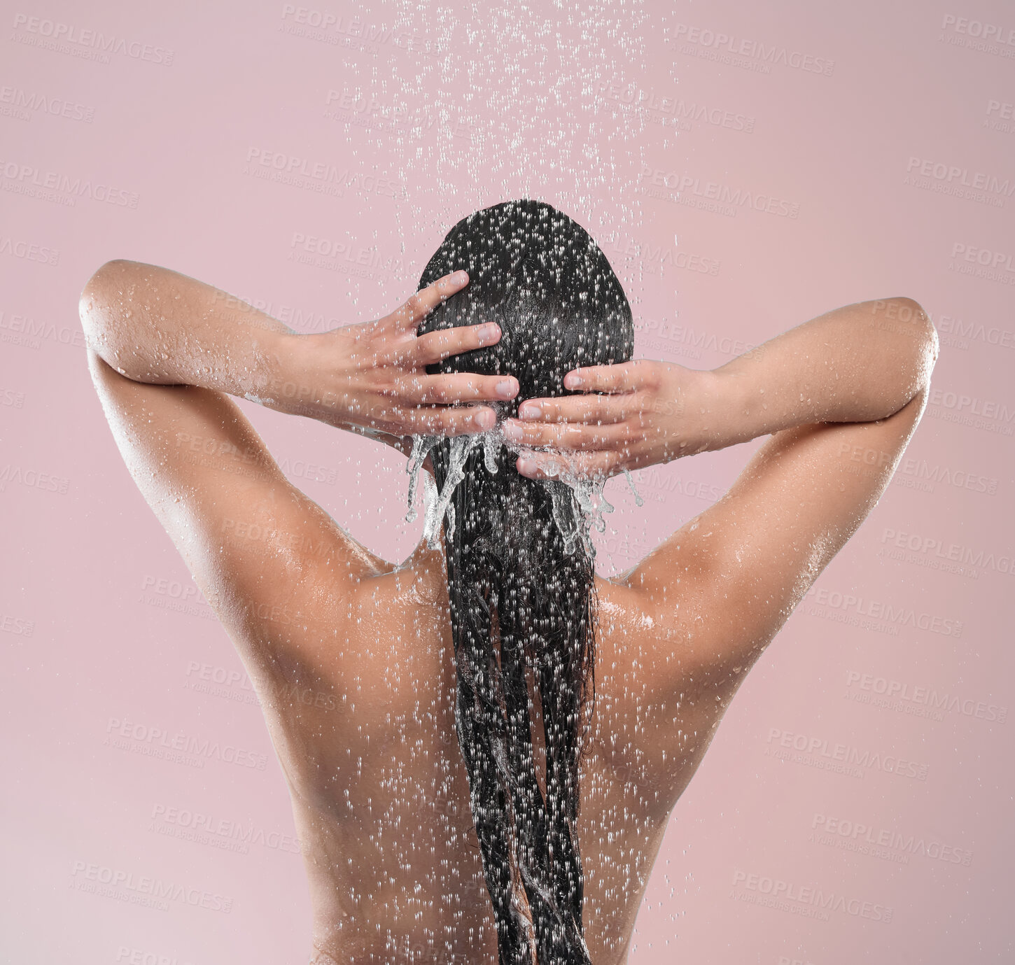 Buy stock photo Shot of a young woman washing her hair against a studio background