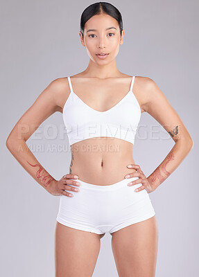Buy stock photo Shot of an attractive young woman standing and posing in her underwear in the studio