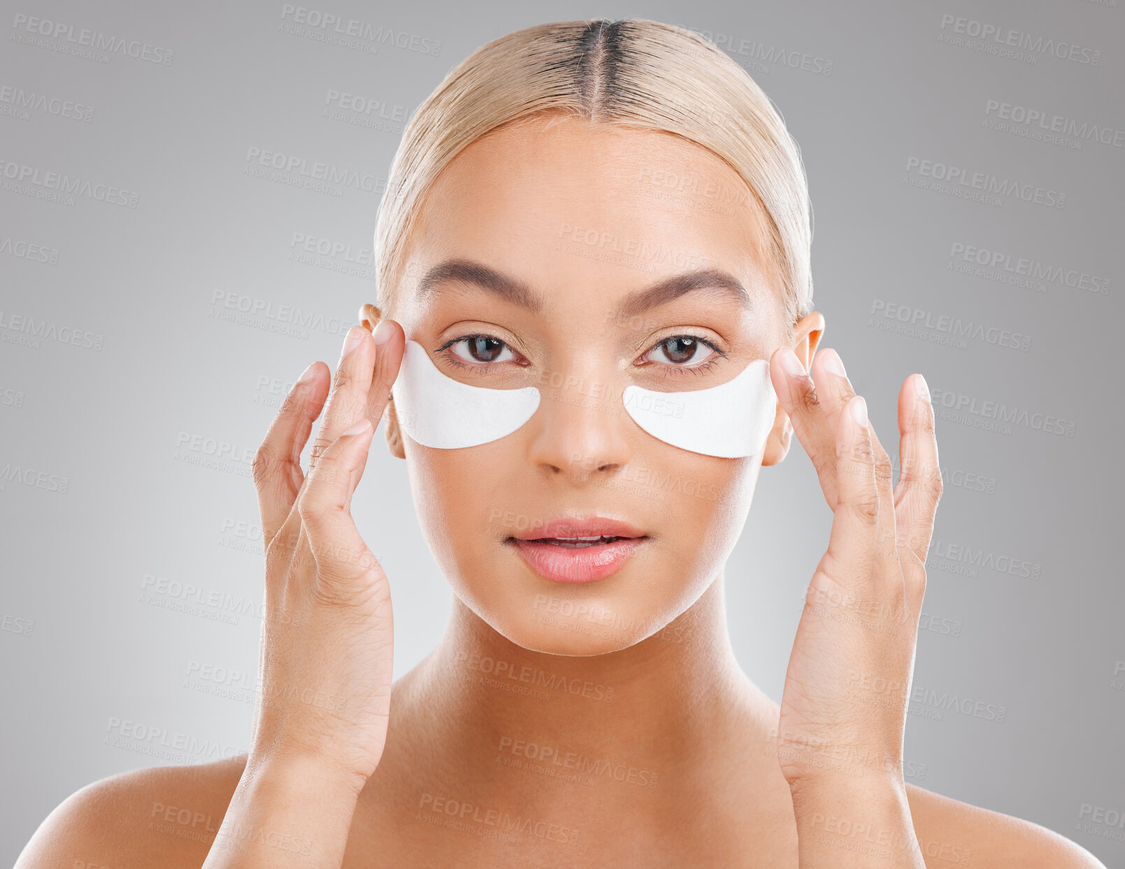 Buy stock photo Shot of an attractive young woman wearing an under eye patch against a studio background