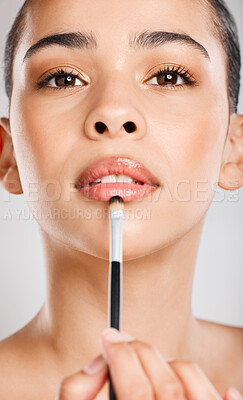 Buy stock photo Studio shot of an attractive young woman applying lipstick against a grey background