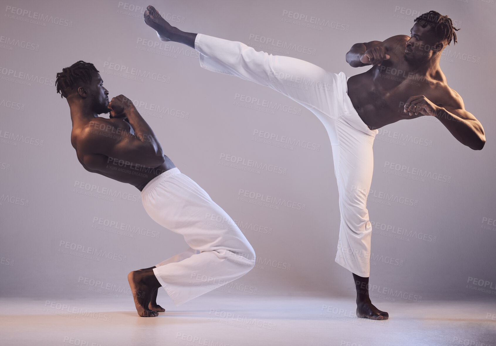 Buy stock photo Shot of two men fighting against a grey background