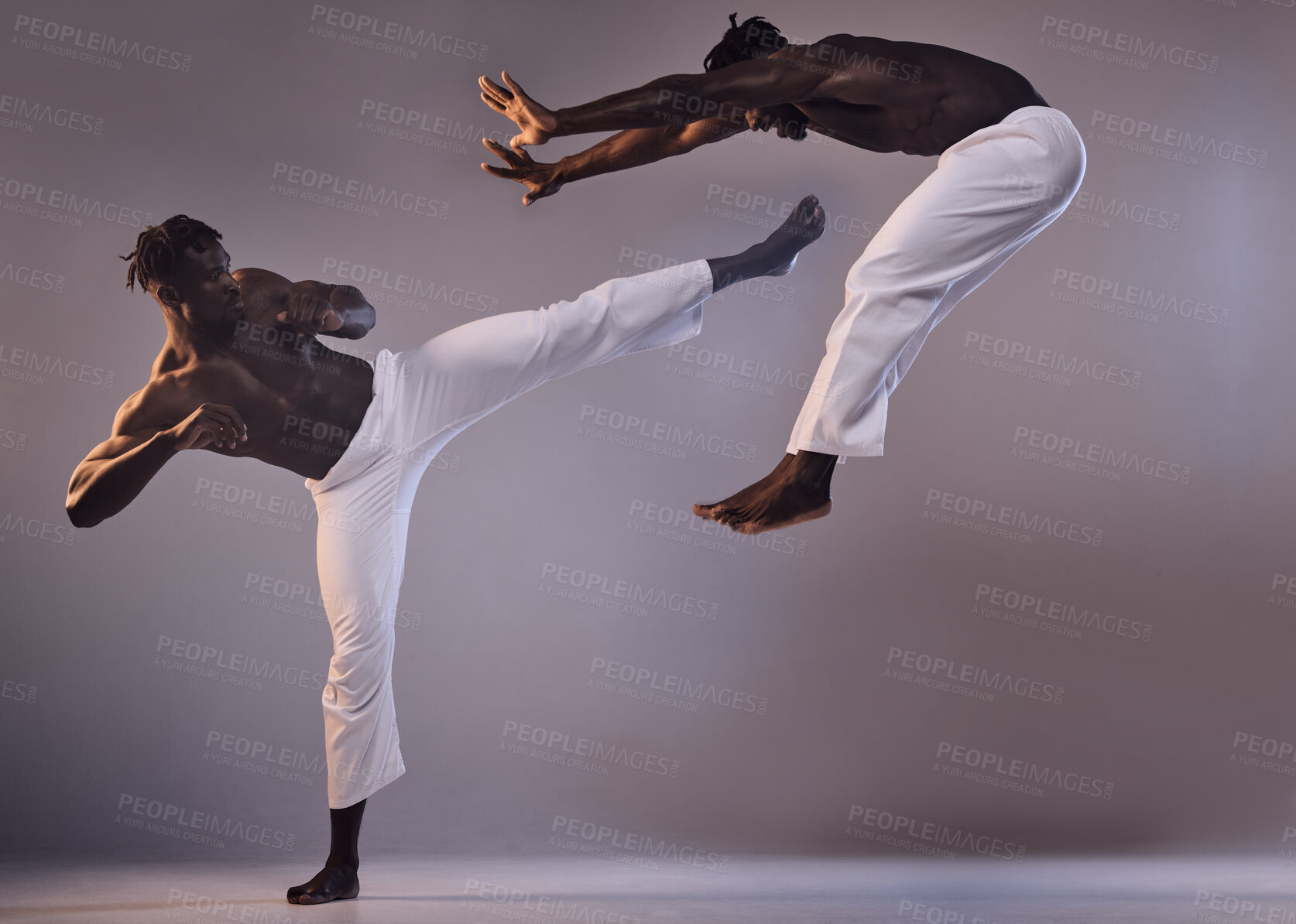 Buy stock photo Shot of two men fighting against a grey background