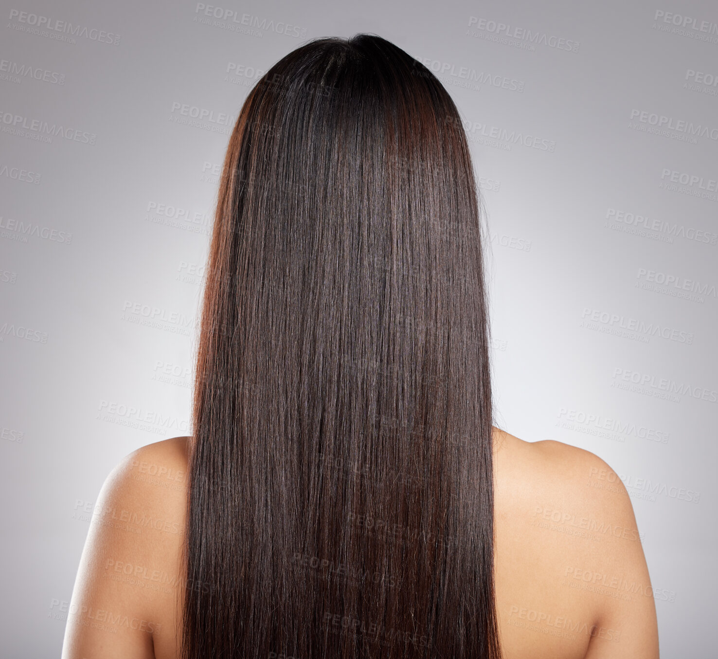 Buy stock photo Rearview shot of a young woman with long silky hair posing against a grey background
